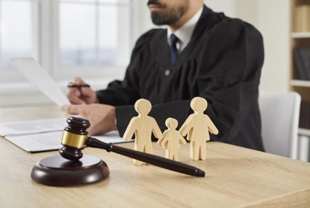 Judge with gavel and wooden family