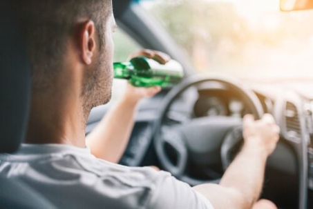 Man driving and drinking a beer